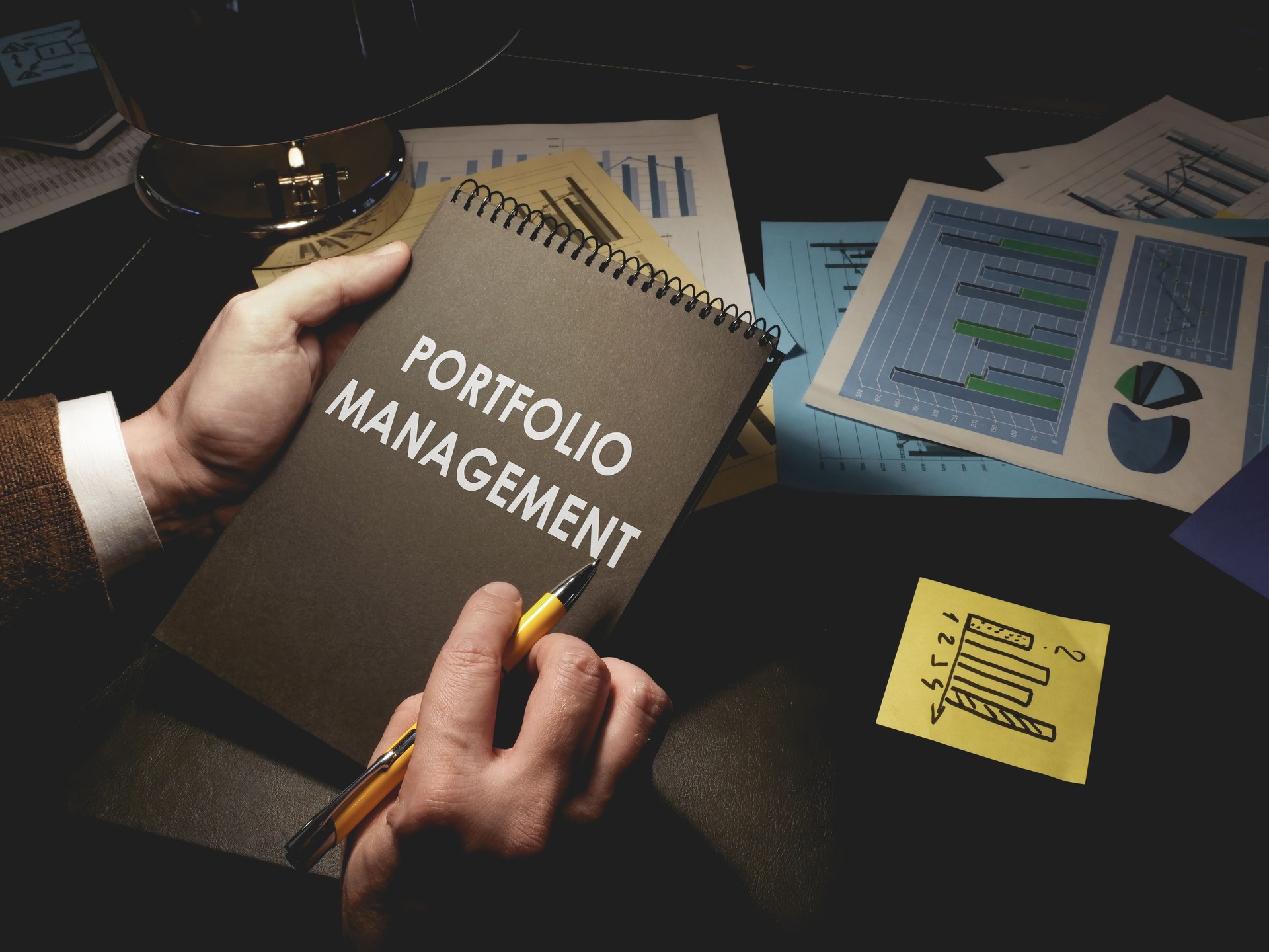 Man makes notes about portfolio management in the notepad.
